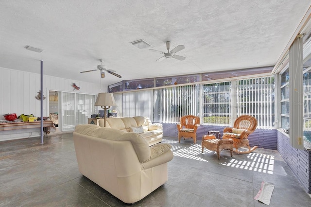 living room featuring ceiling fan and a textured ceiling