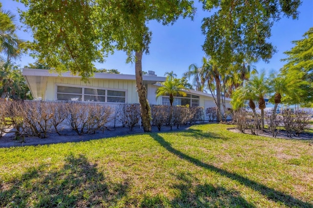 view of side of home with a yard