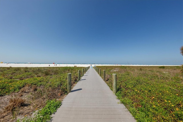 view of community with a water view and a beach view