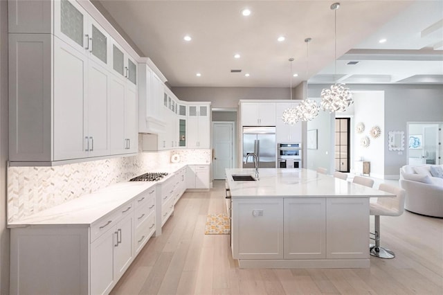 kitchen with stainless steel appliances, pendant lighting, a large island, and sink