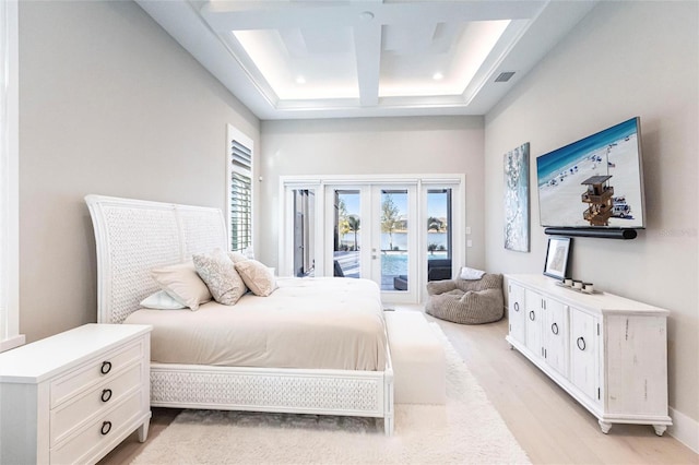 bedroom with access to exterior, a high ceiling, coffered ceiling, light hardwood / wood-style floors, and french doors