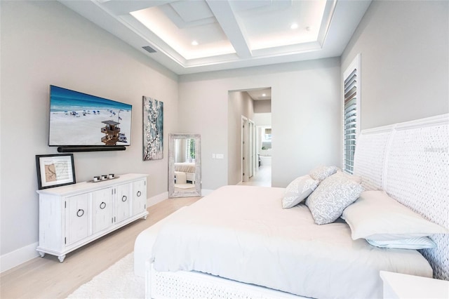 bedroom with beam ceiling, coffered ceiling, light hardwood / wood-style floors, and a towering ceiling