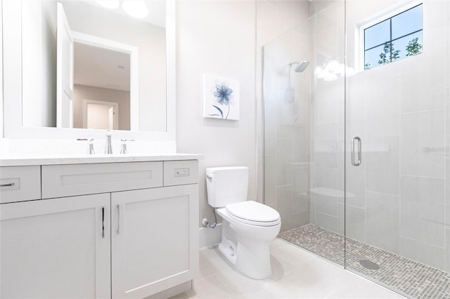 bathroom with a shower with door, vanity, tile patterned floors, and toilet