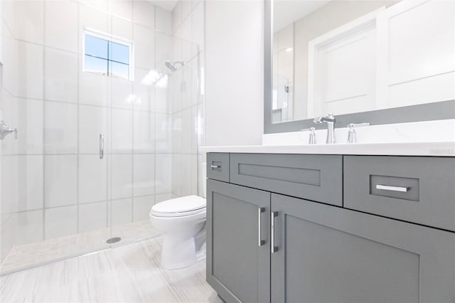 bathroom featuring vanity, an enclosed shower, and toilet