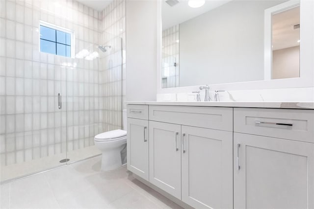 bathroom with vanity, tile patterned flooring, toilet, and walk in shower