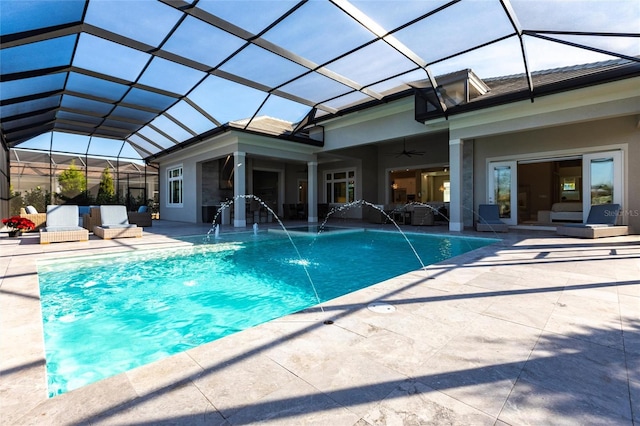 view of swimming pool featuring a lanai, a patio area, pool water feature, and ceiling fan