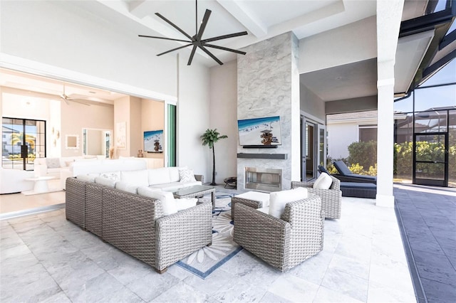 living room with ceiling fan, a fireplace, beam ceiling, and a high ceiling