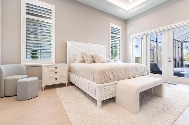 bedroom featuring access to exterior, french doors, and light wood-type flooring