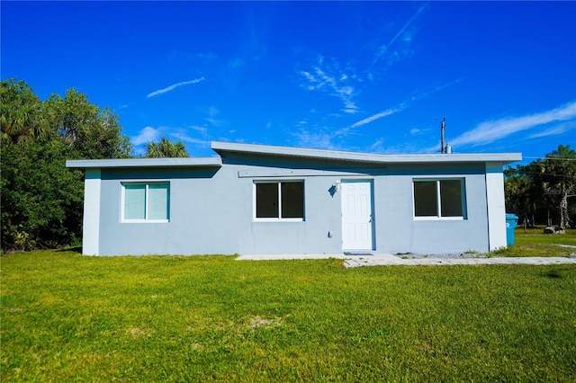 rear view of property featuring a yard