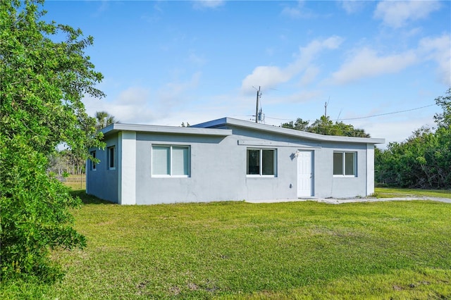 back of house featuring a lawn