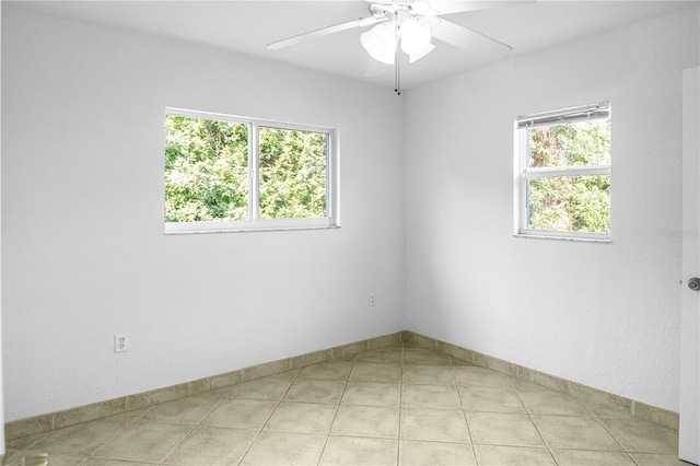 tiled spare room featuring ceiling fan