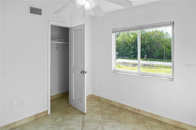 unfurnished bedroom featuring light tile patterned floors, a closet, and ceiling fan