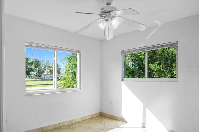 tiled empty room featuring ceiling fan