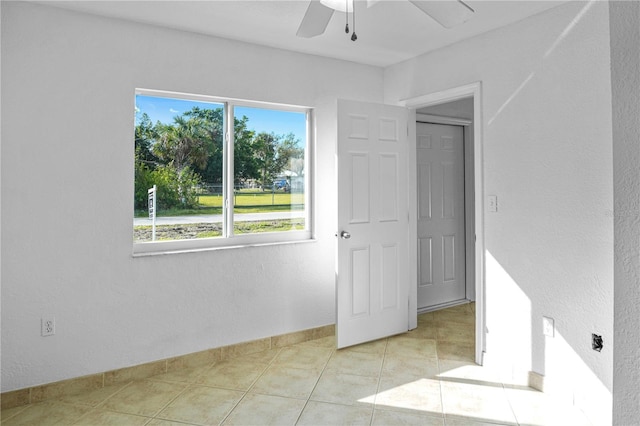 unfurnished room featuring light tile patterned floors and ceiling fan