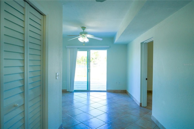 tiled spare room featuring ceiling fan