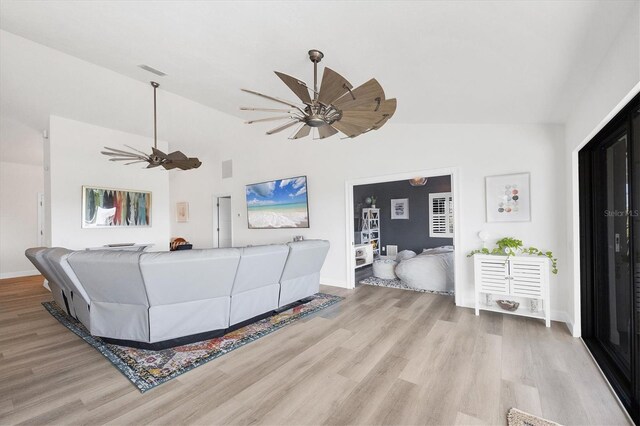 living room with light hardwood / wood-style flooring, ceiling fan, and vaulted ceiling