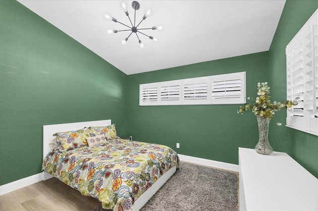 bedroom with an inviting chandelier and wood-type flooring