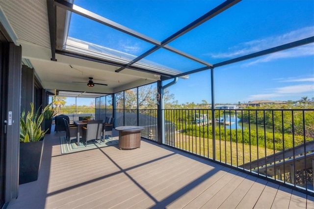 sunroom / solarium featuring a water view and ceiling fan