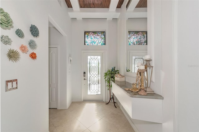 entrance foyer featuring beamed ceiling and light tile patterned floors