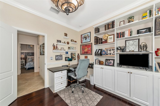 office space with ornamental molding, dark wood-type flooring, and built in desk