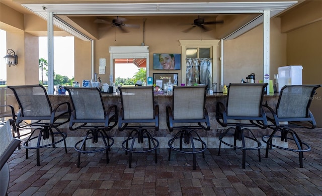 view of patio featuring ceiling fan and an outdoor bar