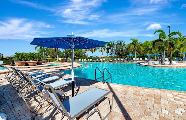 view of swimming pool with a jacuzzi and a patio