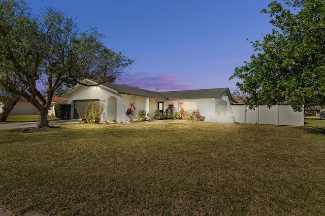 ranch-style home with a garage and a lawn