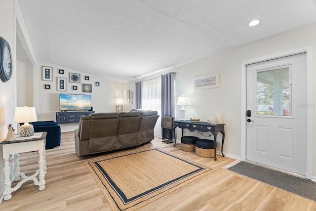 living room with a textured ceiling and light hardwood / wood-style floors