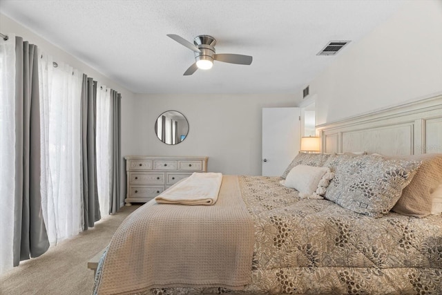 bedroom with light colored carpet, a textured ceiling, and ceiling fan