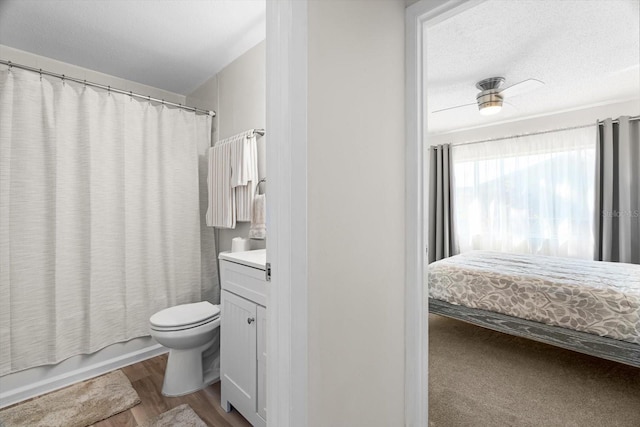 full bathroom with vanity, shower / bath combo, a textured ceiling, and toilet