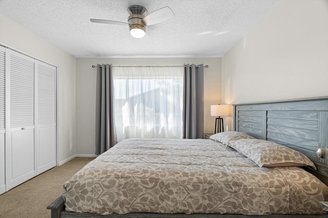 bedroom with a textured ceiling, light colored carpet, a closet, and ceiling fan