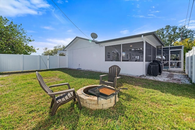 view of yard with a sunroom and a fire pit