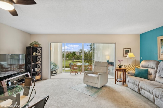 carpeted living room with ceiling fan and a textured ceiling