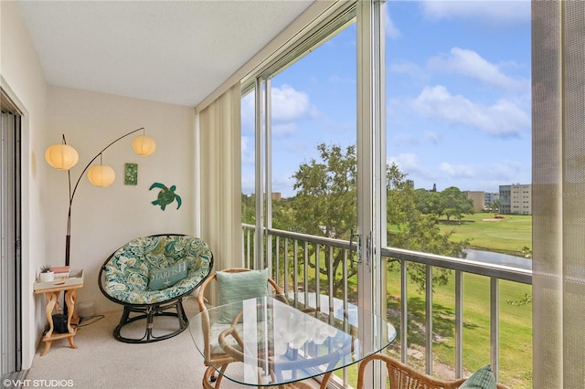 sunroom / solarium featuring a water view