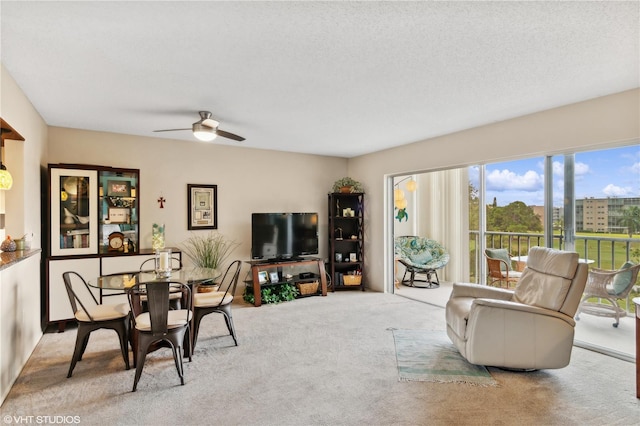 carpeted living room with ceiling fan and a textured ceiling