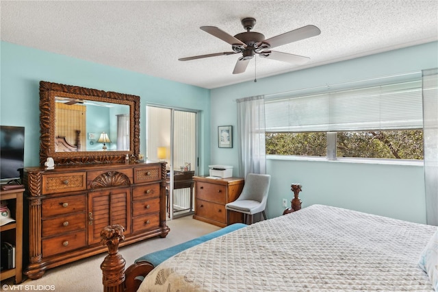 bedroom with ceiling fan, light colored carpet, and a textured ceiling