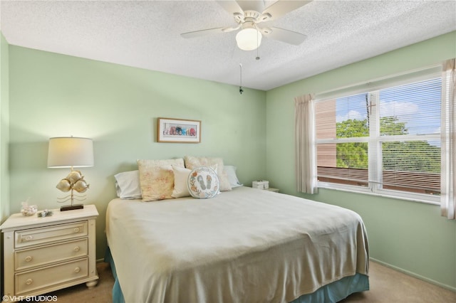 carpeted bedroom featuring ceiling fan and a textured ceiling