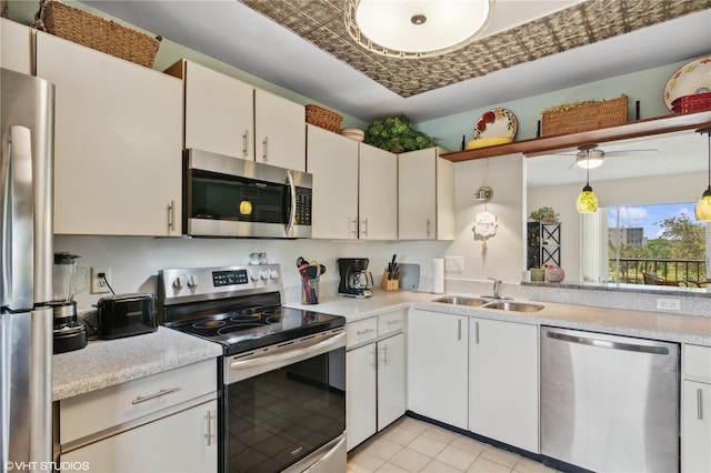 kitchen with stainless steel appliances, sink, pendant lighting, and white cabinets