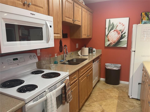 kitchen with white appliances, sink, and light tile patterned floors