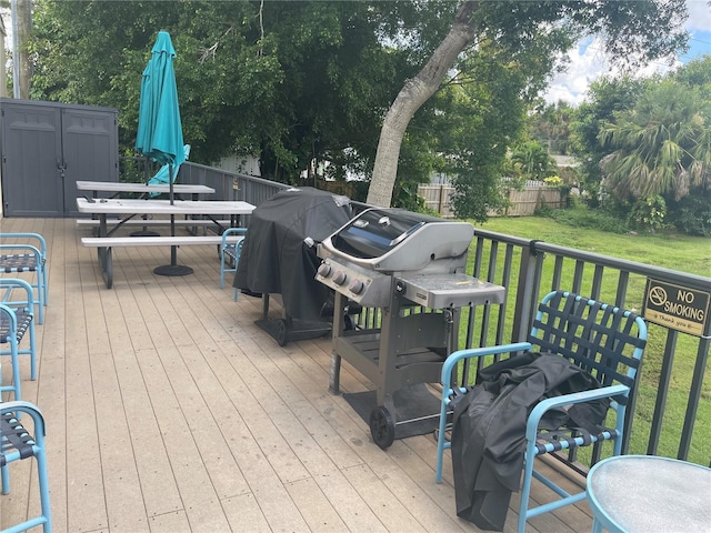 wooden terrace with area for grilling and a lawn