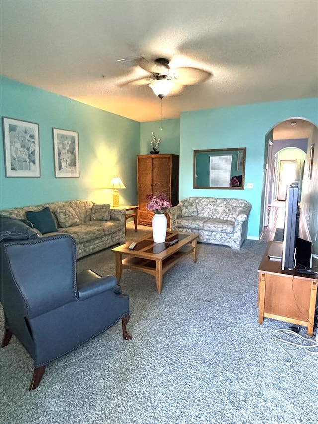 carpeted living room with ceiling fan and a textured ceiling