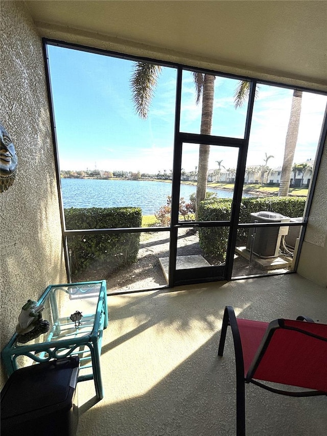 sunroom / solarium with a water view and plenty of natural light