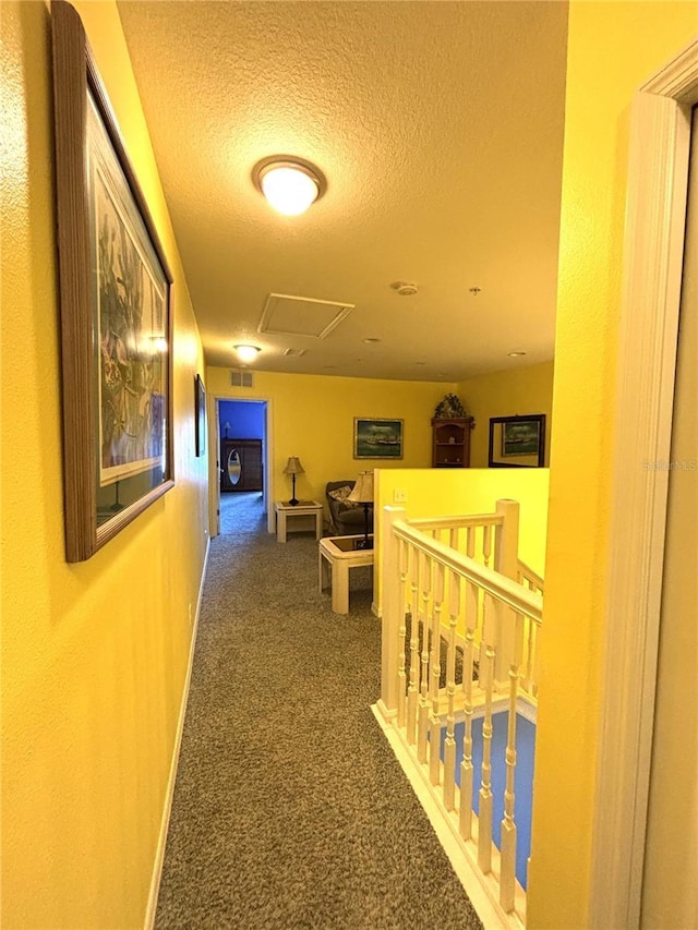 hall with a textured ceiling and carpet