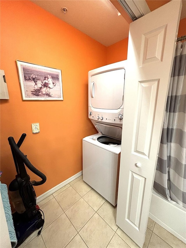 washroom with stacked washer and dryer and light tile patterned floors