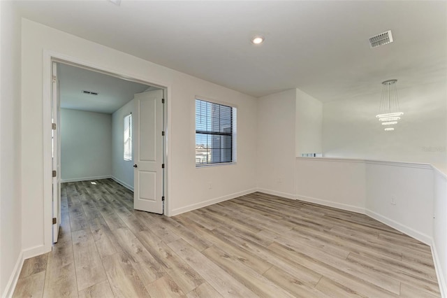 spare room with light wood-style floors, recessed lighting, visible vents, and baseboards