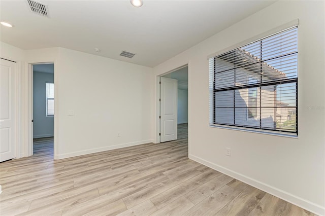 unfurnished room with baseboards, recessed lighting, visible vents, and light wood-style floors