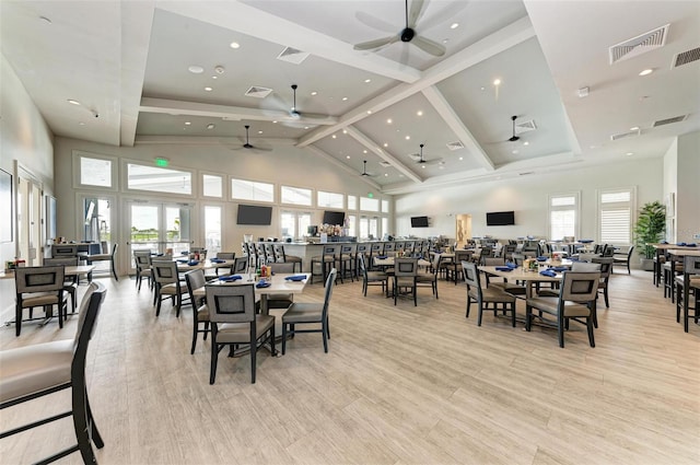 dining area with high vaulted ceiling, plenty of natural light, visible vents, and light wood-style floors