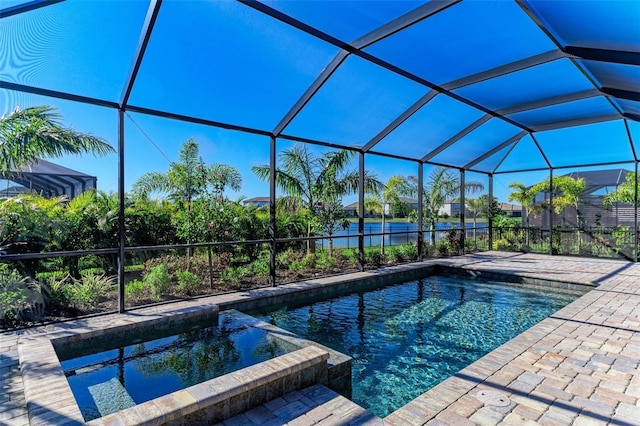 view of pool with glass enclosure, a patio area, and a pool with connected hot tub