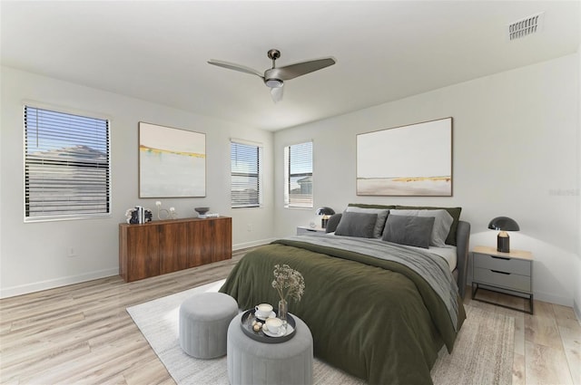 bedroom featuring light wood-type flooring, baseboards, visible vents, and ceiling fan