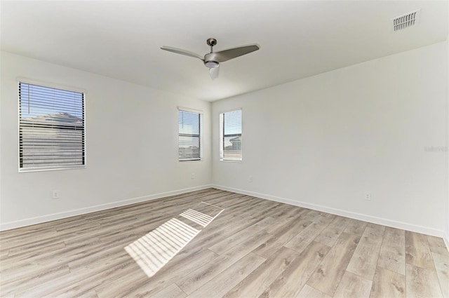 unfurnished room featuring light wood-style floors, visible vents, ceiling fan, and baseboards